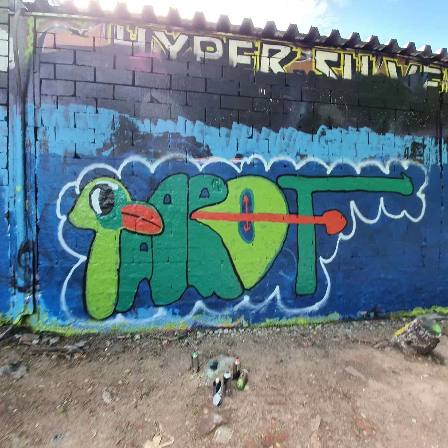 Graffiti på tegelvägg med färgburkar nedanför