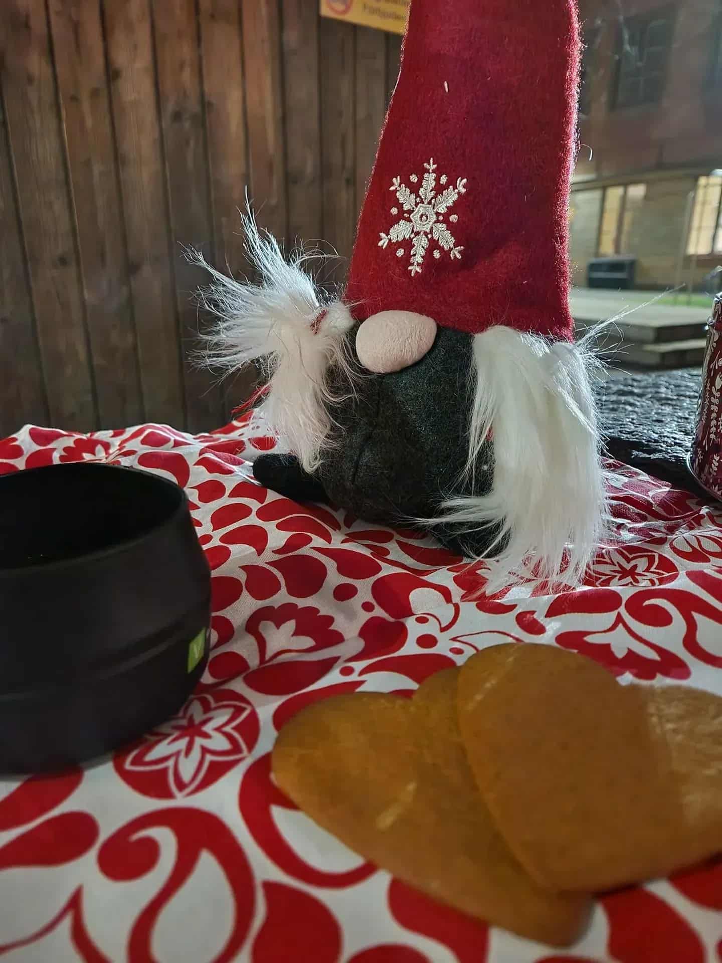 Christmas decoration: gnome with red hat, white beard, gingerbread cookies and black mug