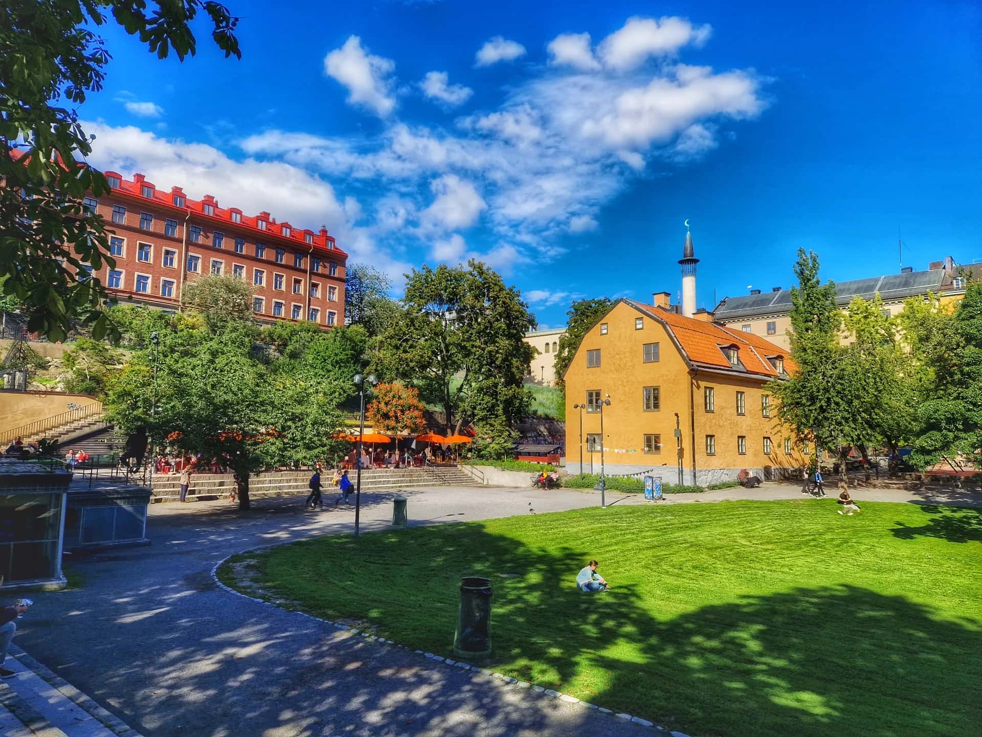 Björns trädgård på Södermalm under en stadsvandring i Stockholm, med gröna gräsmattor, träd och historiska hus