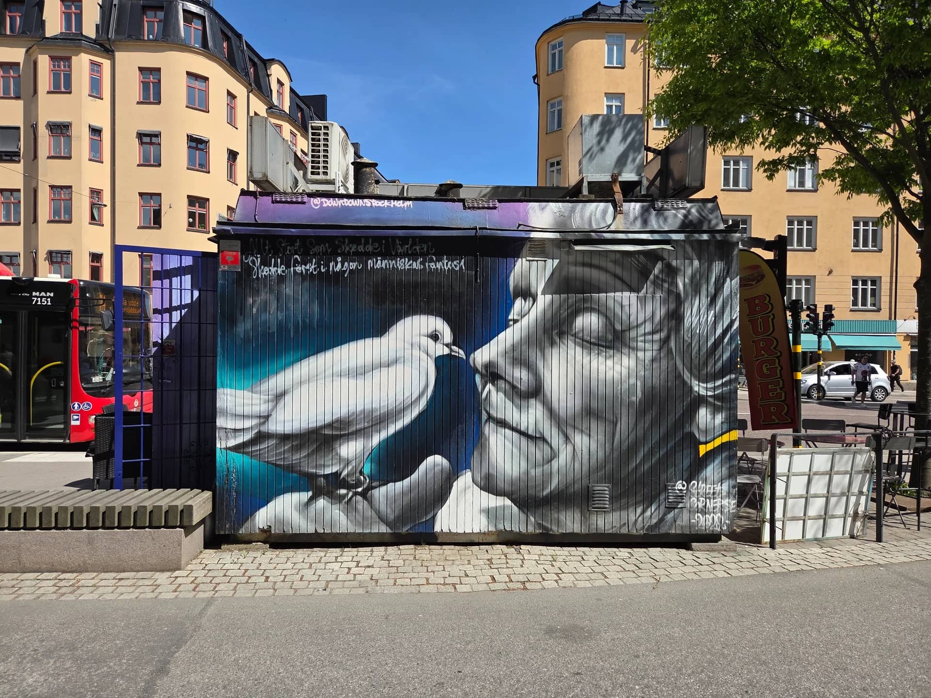 Mural painting on wooden planks: dove and face in black and white against a blue background