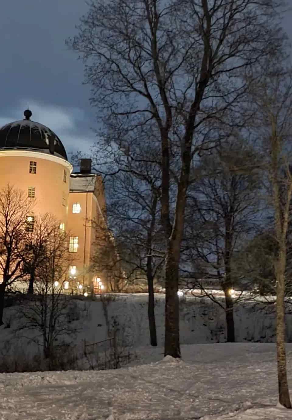Hus med torn och tända fönster, snöigt landskap