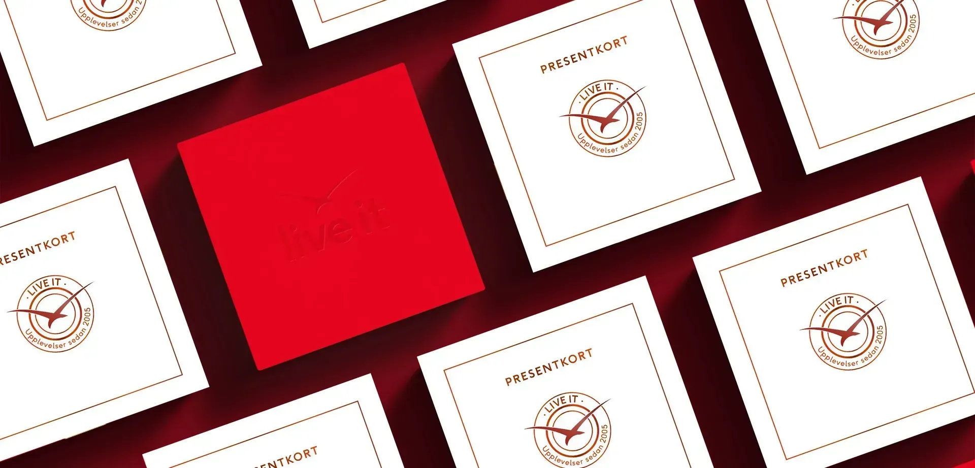 Röda och vita presentkort "Live it" med logotyp, arrangerade på röd bakgrund