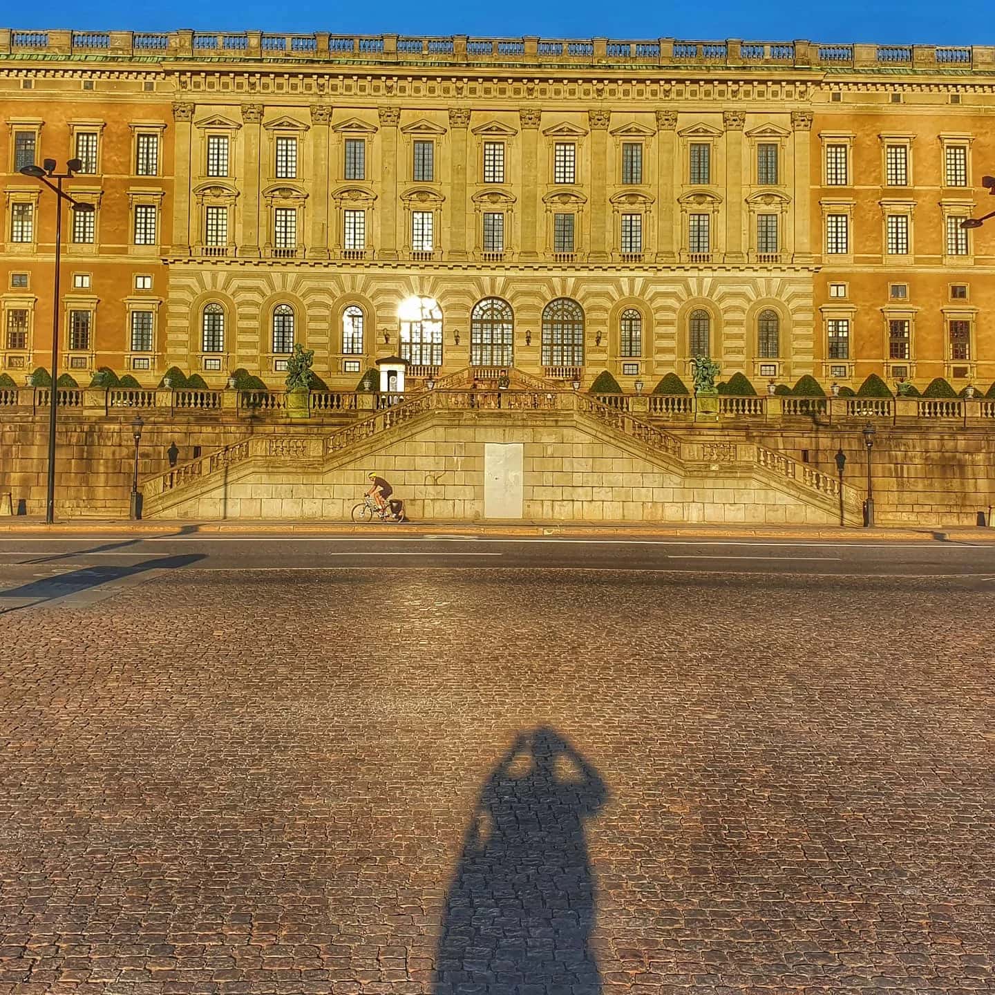 Kungliga slottet i Stockholm, en klassisk syn på en stadsvandring i Stockholm, med cyklist och skugga