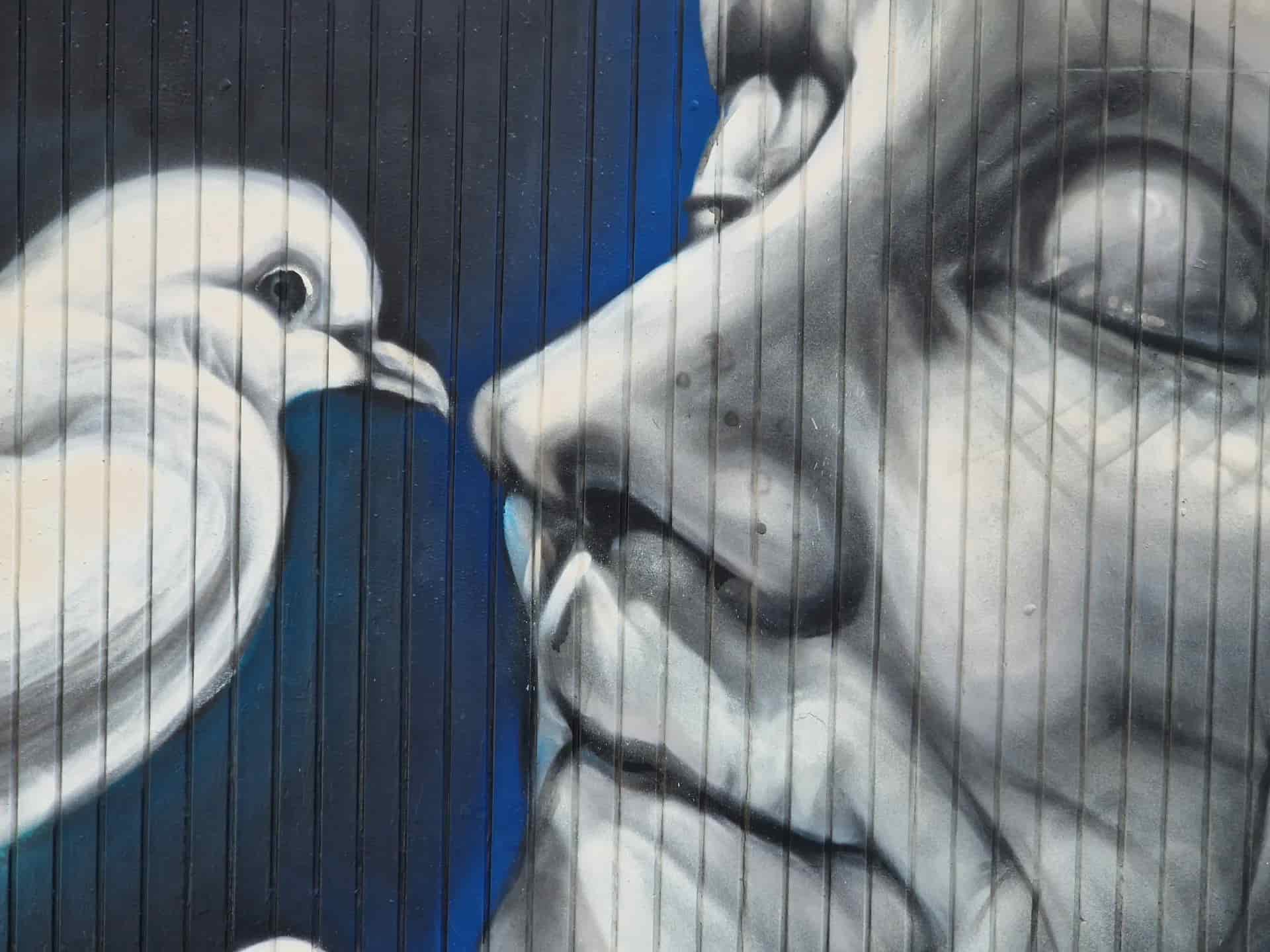 Mural: Face in grayscale and white dove. Vertical lines in the background