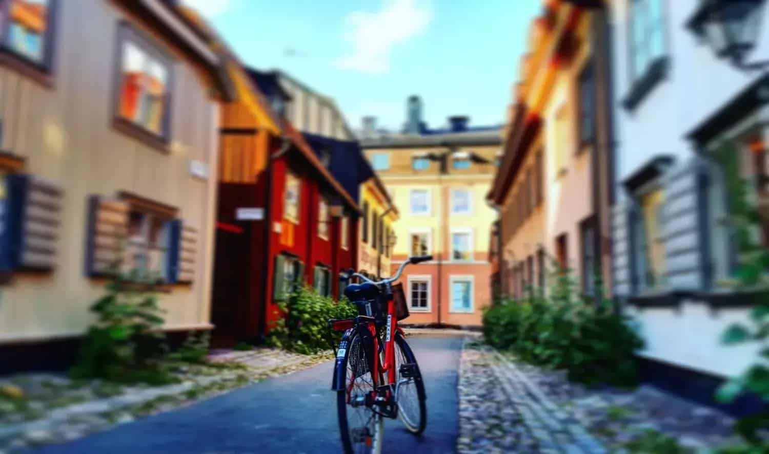 Red bicycle parked on a cobblestone street among colorful wooden houses